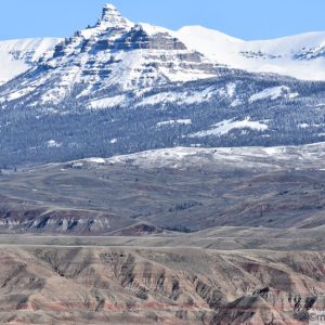 Layered mountains in the foreground with snow-capped mountains in the background